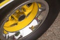 Yellow and chrome wheel of an old timer sports car with black tire reflecting surroundings and photographer Royalty Free Stock Photo