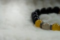 Yellow Chrysoberyl Cat`s Eye stone and Lava stone.Luck fortune stone bracelet with yellow and black tone on white wool background Royalty Free Stock Photo