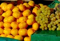 Yellow clementine fruit and white grape on display on deep green waxed vinyl cover Royalty Free Stock Photo