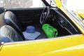 Yellow classic cabriolet with a sun hat on the driver seat