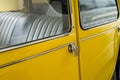 Yellow classic car door handle and windows with the black car seats Royalty Free Stock Photo