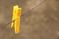 A yellow clean plastic cloth peg hanging on a wire Royalty Free Stock Photo