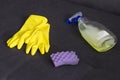 Yellow cleaning gloves, a sponge and a cleanser on the couch screen Royalty Free Stock Photo