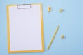 Yellow clipboard with blank white paper on blue background