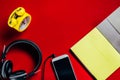 Yellow clock, black headphones,Open notebooks for copy space text. Red background,