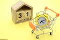 A yellow clock on a cart in a yellow background