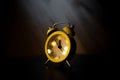 Office clock on a black desk shownig time. Yellow clock on a dark background Royalty Free Stock Photo