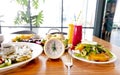 Yellow clock with a healthy food and drink background for a dinnertime with Intermittent fastin concept Royalty Free Stock Photo