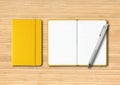 Yellow closed and open lined notebooks with a pen on wooden background Royalty Free Stock Photo