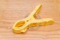 Yellow clothespin on wood background