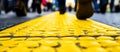 Yellow cobblestones on sidewalks function as guiding pathways, enabling blind pedestrians to navigate safely through Royalty Free Stock Photo