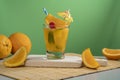 Yellow cocktail in glass glass filled with ice and mint leaves garnished with orange slice, cherry, sorbet and yellow umbrella on Royalty Free Stock Photo