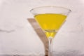 Yellow cocktail in martini glass on a white background Royalty Free Stock Photo