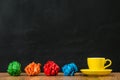 Yellow coffee cup group with colored paper balls Royalty Free Stock Photo