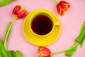 yellow coffee cup and red tulips layout on pastel pink background Royalty Free Stock Photo