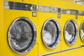 Yellow coin washing machines with laundry in it