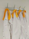 Yellow collar labcoats on coat rack