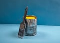 Yellow color emulsion paint tin with new brush. Home renovation concept or paint mockup with blue banner Royalty Free Stock Photo