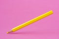 Yellow color pencil levitating over a pink background Royalty Free Stock Photo