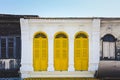 Yellow color wooden arched window on white cement wall in chino Portuguese style at Phuket old town, Thailand Royalty Free Stock Photo