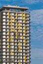 Yellow colored apartment building at noon against blue sky. Royalty Free Stock Photo