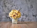 Yellow colored artificial rose flowers bouquet in pot on table Royalty Free Stock Photo