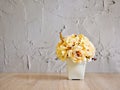 Yellow colored artificial rose flowers bouquet in pot on table Royalty Free Stock Photo