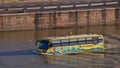 Yellow colored funny looking amphibious bus vehicle on Danube River conducting tour for tourists on land and water.