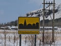 Yellow colored town sign with black symbol of small village Kirkjubaejarklaustur in southern Iceland on sunny winter day.