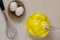 Yellow colored whipped egg whites in glass bowl. Top view Royalty Free Stock Photo