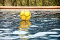 Yellow colorful beach ball floating in a pool Royalty Free Stock Photo