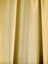 Yellow curtain texture and background. Vertical photo image. Royalty Free Stock Photo