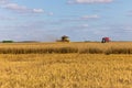 Yellow combine harvester on a wheat field with blue sky Royalty Free Stock Photo