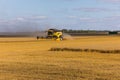 Yellow combine harvester on a wheat field with blue sky Royalty Free Stock Photo