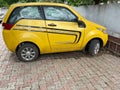 A yellow compact electric car with designs on the sides standing Royalty Free Stock Photo