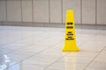 Yellow cone cautioning for wet floor in english and spanish in the hotel