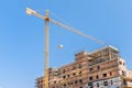 Yellow constrcution crane lifts an object to a building under co Royalty Free Stock Photo