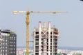 Yellow construction crane is building new modern skyscraper. Royalty Free Stock Photo