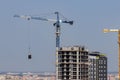 Yellow construction crane is building new modern skyscraper. Royalty Free Stock Photo