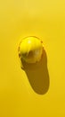 Yellow construction hard hat casting shadow on yellow background, industrial concept Royalty Free Stock Photo