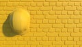 Yellow construction helmet on a background of a yellow brick wall. Monochrome illustration with copy space. Builder Work Uniform.