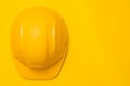 Yellow construction helmet on a yellow background, head protection, concept, top view