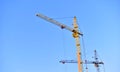 Yellow construction tower crane in the city against the sky Royalty Free Stock Photo