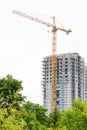 Yellow construction tower crane and unfinished block of flats