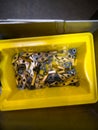 Yellow container filled with various metal tools and attachments for workshop use and production tasks Royalty Free Stock Photo