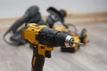 Yellow cordless drill with additional power tools in the background. Construction work, home improvement, mechanical tasks and Royalty Free Stock Photo