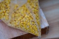 Yellow Corn Kernels inside Transparent Plastic Bag on Wooden Table Royalty Free Stock Photo