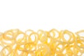 Yellow corn sticks rings as decorative food border isolated on white background. Top view. Royalty Free Stock Photo