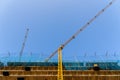 Yellow crane in a construction site to lift large weights of construction material and for the masons to complete their work Royalty Free Stock Photo
