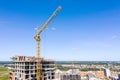 Yellow crane near the building under construction against blue sky Royalty Free Stock Photo